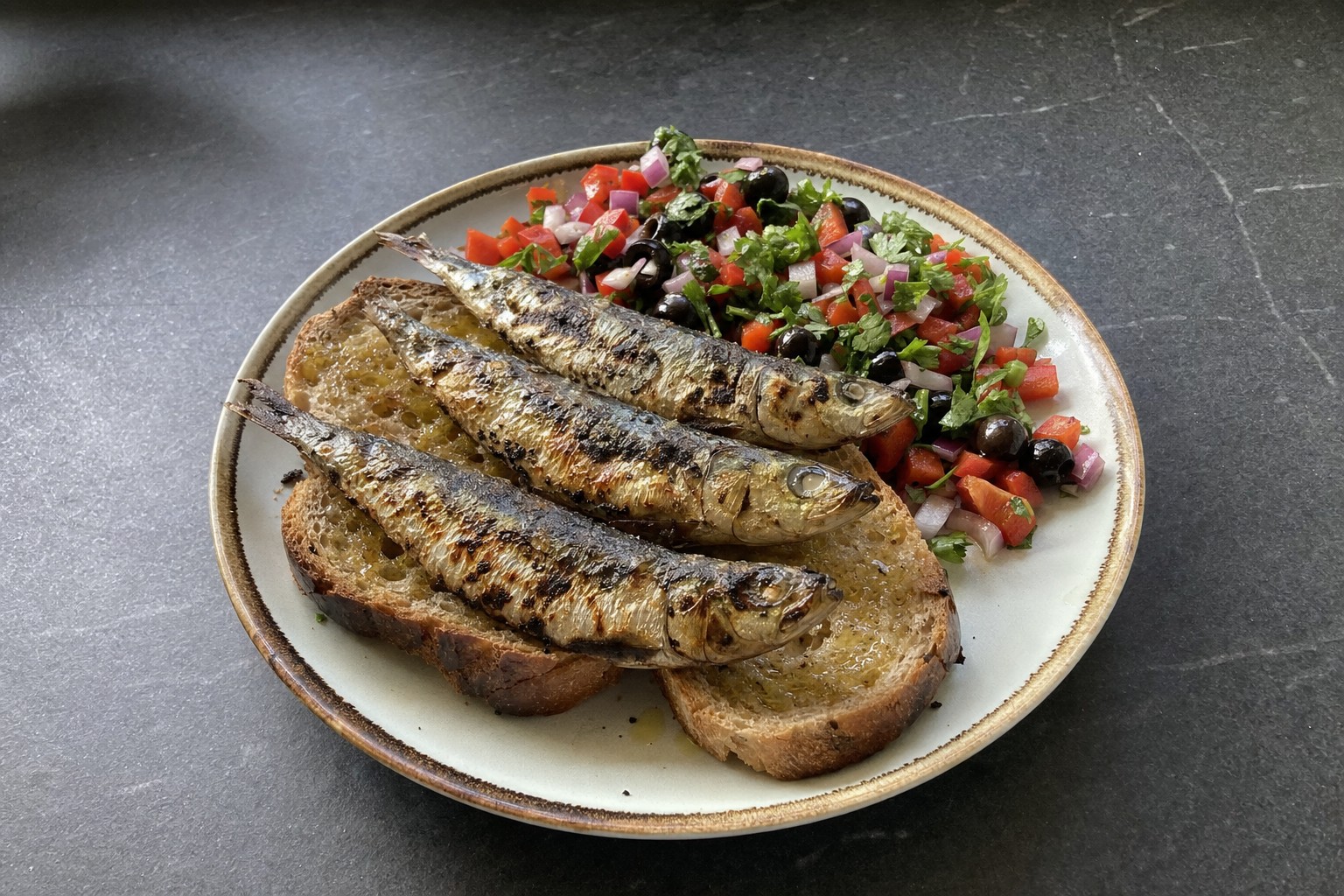 Sardinhas assadas no pão com salada de pimentos
